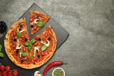 Tasty pizza with basil, olives and ingredients on grey textured table, flat lay. Space for text