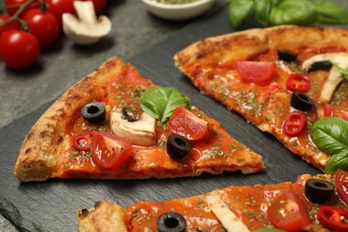 Photo of Tasty pizza with basil, olives and tomato on grey table, closeup