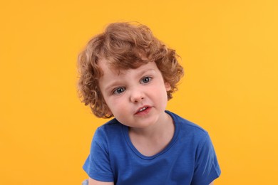 Photo of Portrait of cute little boy on yellow background
