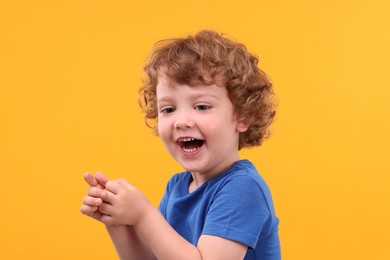 Photo of Portrait of emotional little boy on yellow background