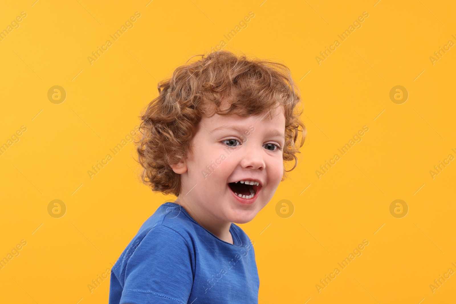 Photo of Portrait of emotional little boy on yellow background