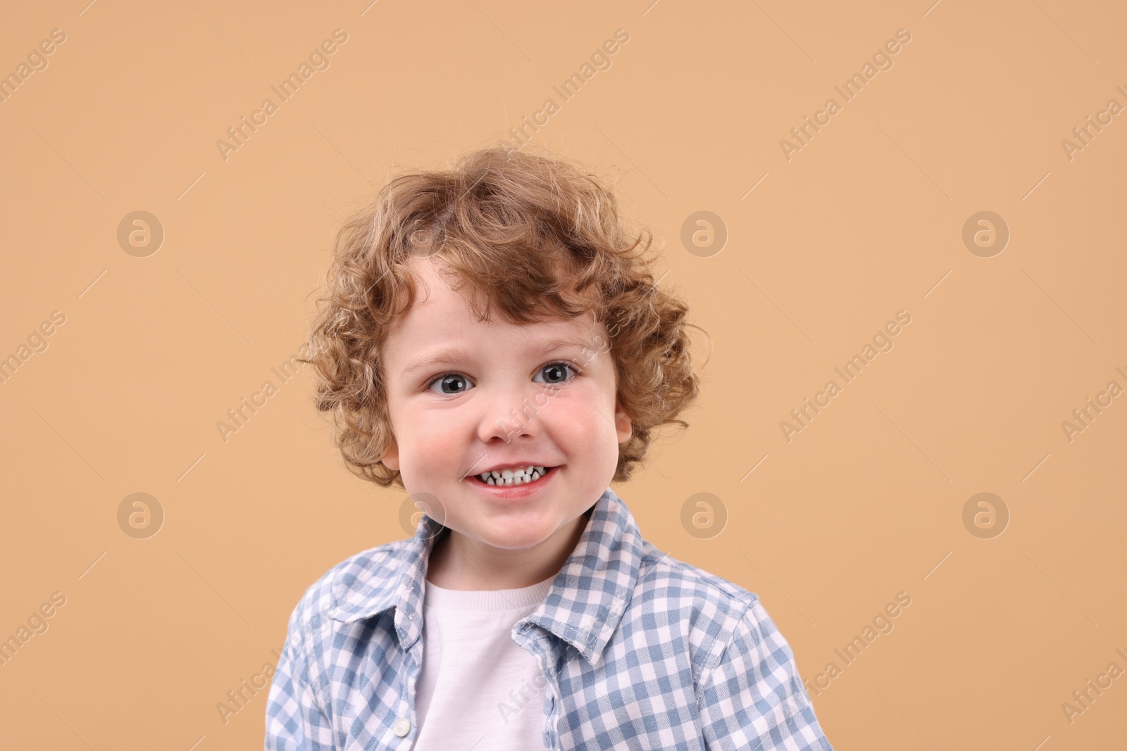 Photo of Portrait of cute little boy on beige background