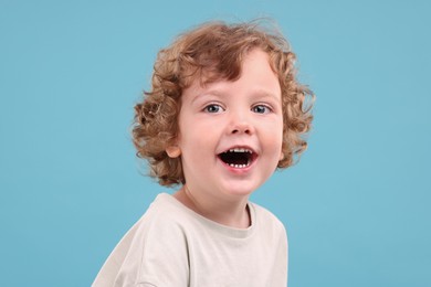 Photo of Portrait of emotional little boy on light blue background