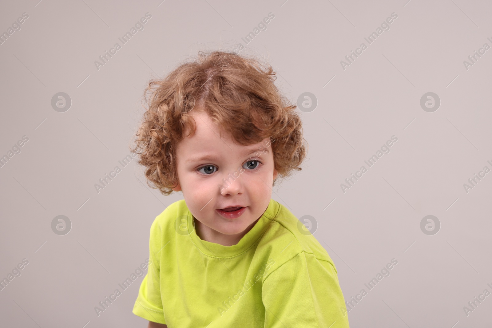 Photo of Portrait of cute little boy on grey background