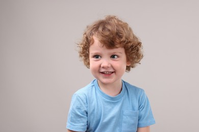 Photo of Portrait of cute little boy on grey background