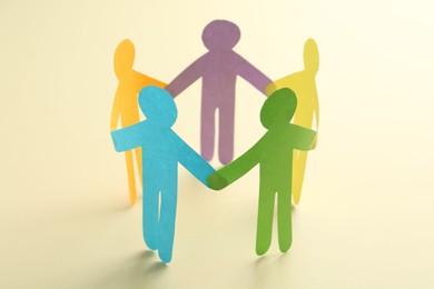 Photo of Equality concept. Paper human figures on beige background, closeup