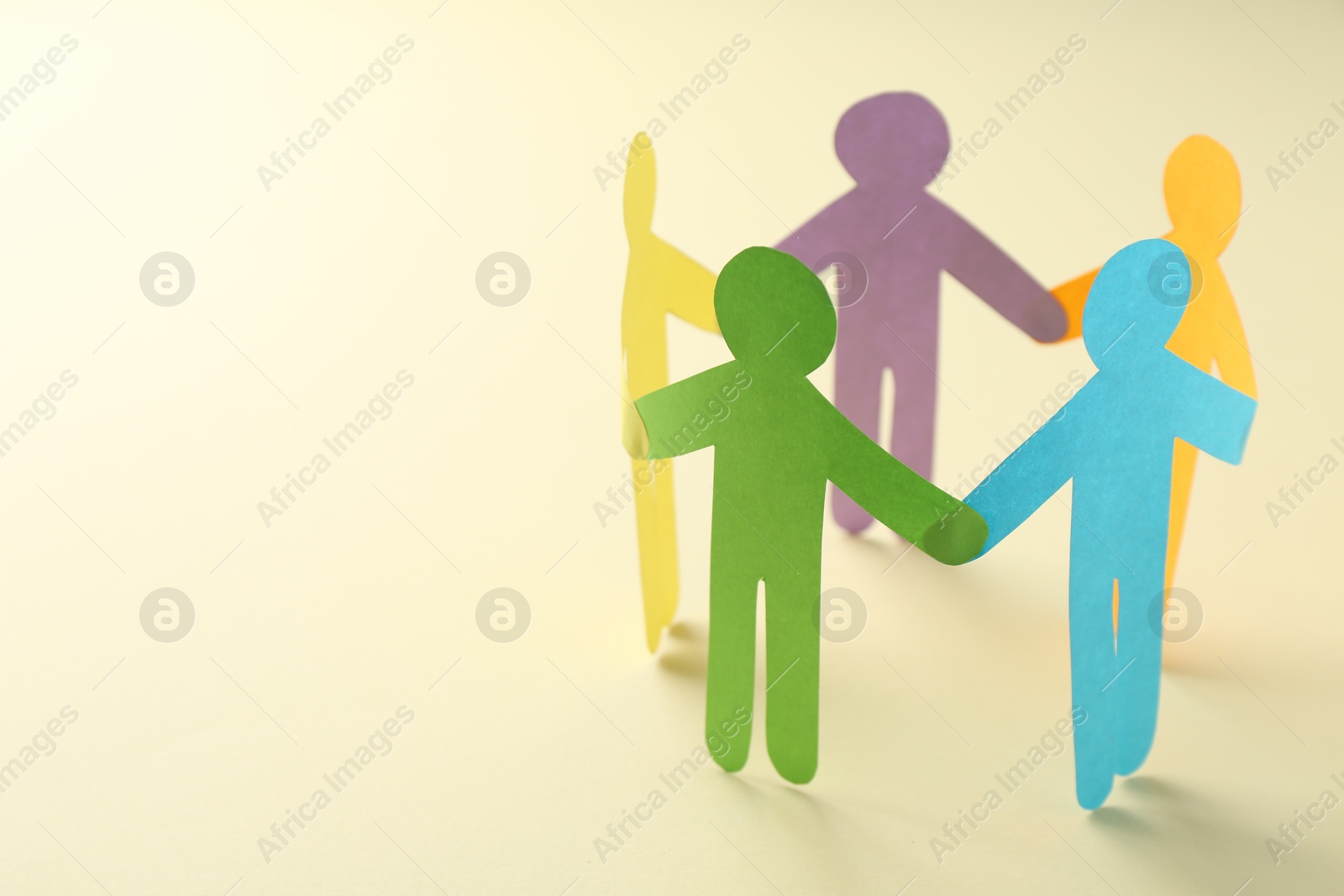 Photo of Equality concept. Paper human figures on beige background, closeup. Space for text