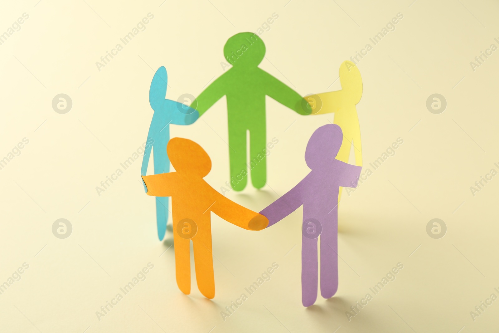 Photo of Equality concept. Paper human figures on beige background, closeup