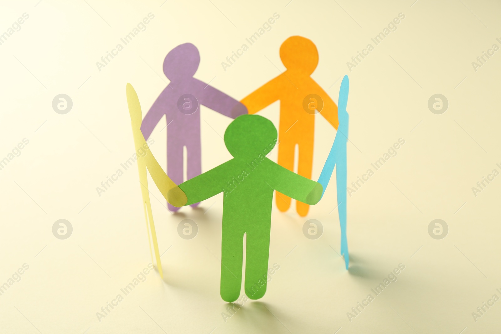 Photo of Equality concept. Paper human figures on beige background, closeup