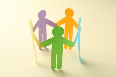 Photo of Equality concept. Paper human figures on beige background, closeup