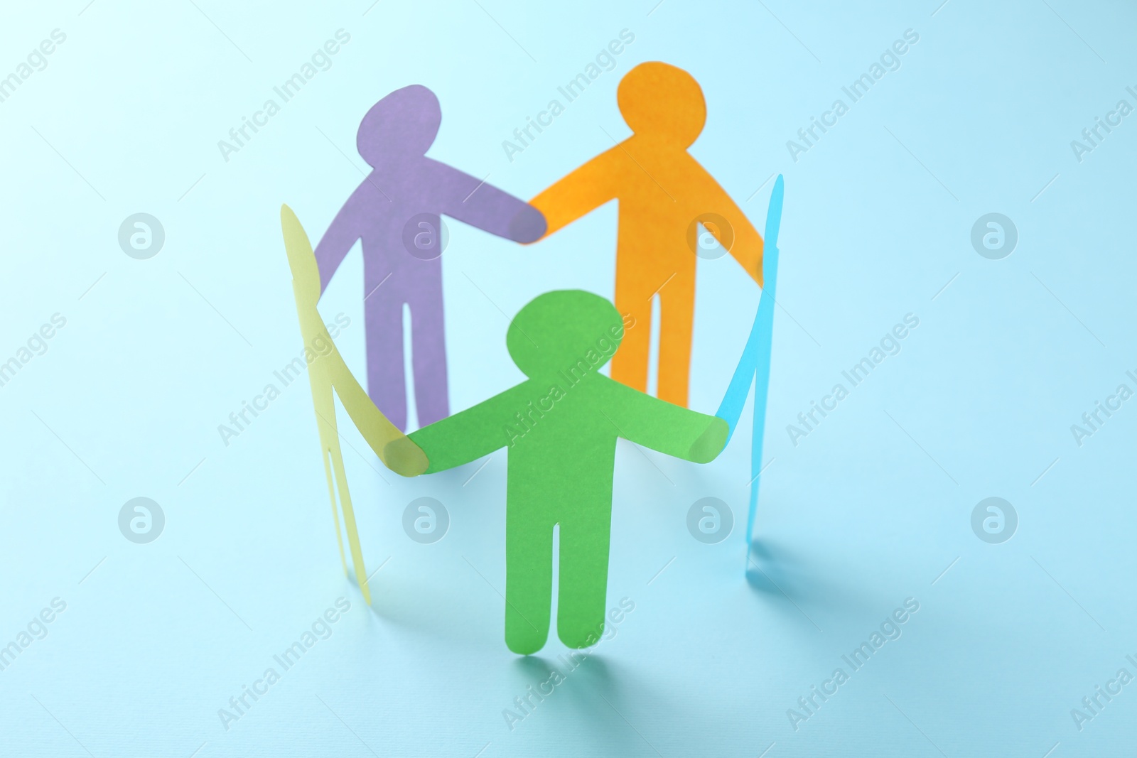 Photo of Equality concept. Paper human figures on light blue background, closeup