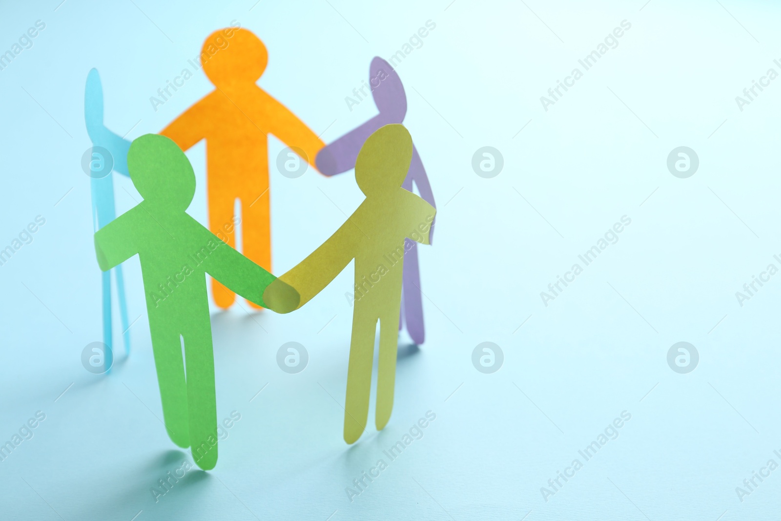 Photo of Equality concept. Paper human figures on light blue background, closeup. Space for text