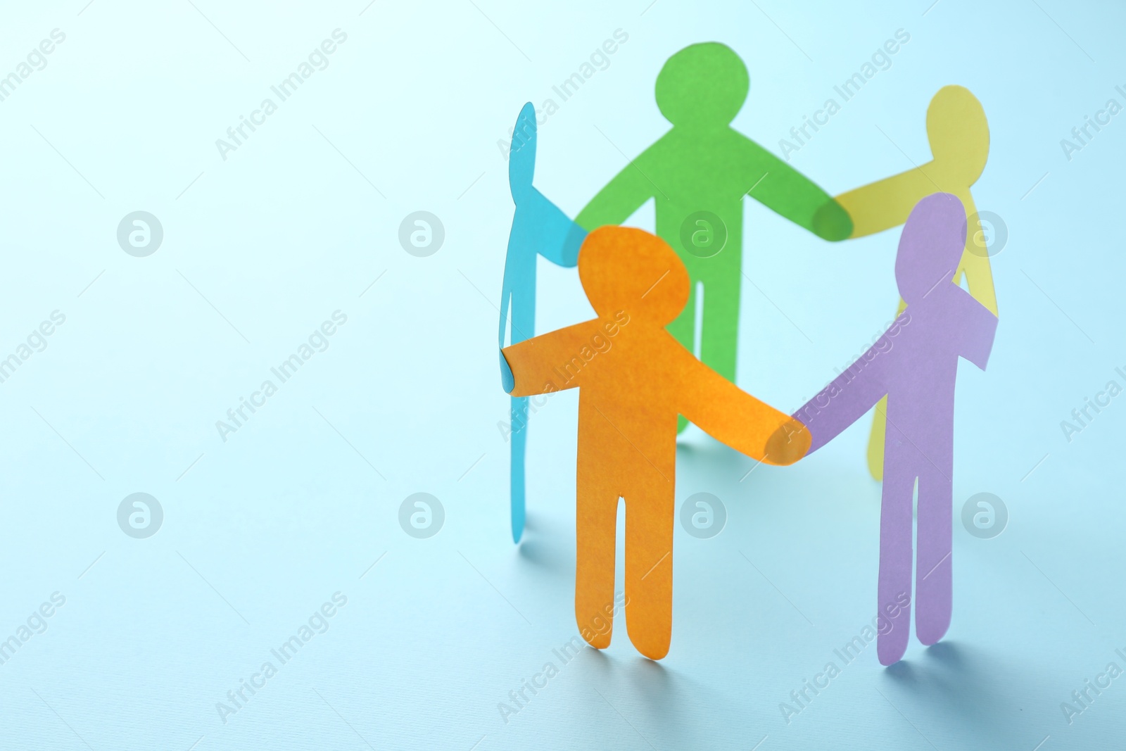 Photo of Equality concept. Paper human figures on light blue background, closeup. Space for text