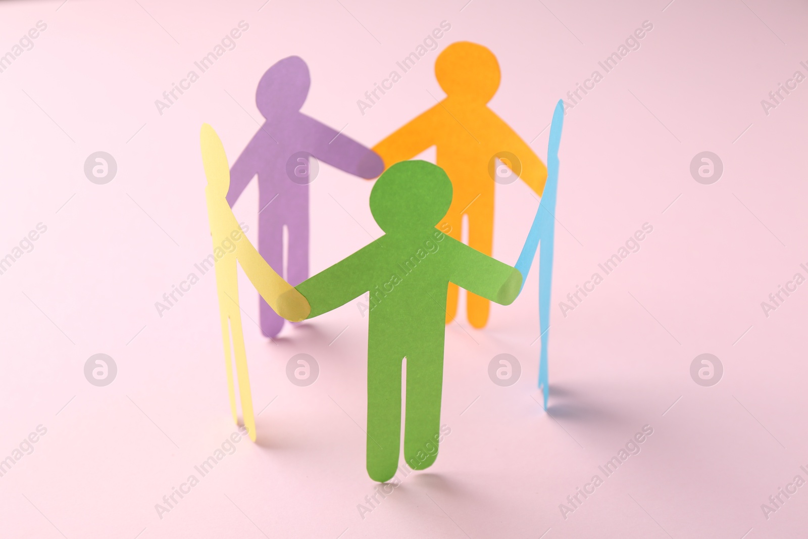 Photo of Equality concept. Paper human figures on pink background, closeup