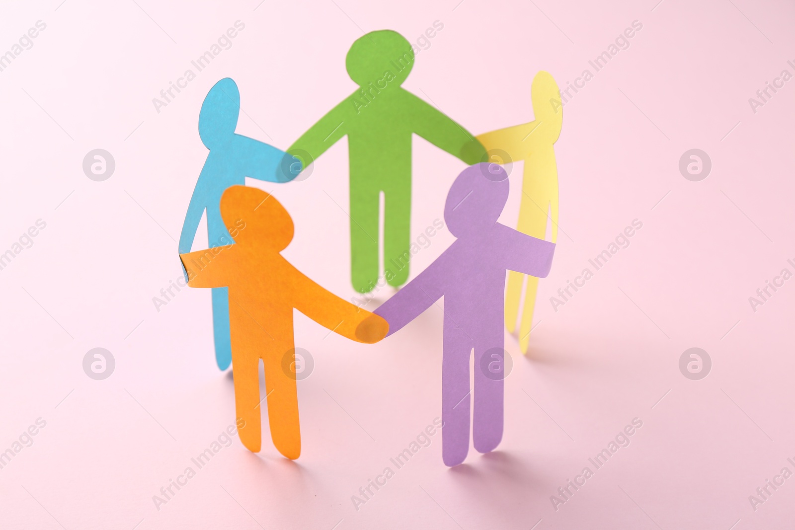 Photo of Equality concept. Paper human figures on pink background, closeup