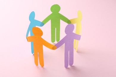 Photo of Equality concept. Paper human figures on pink background, closeup