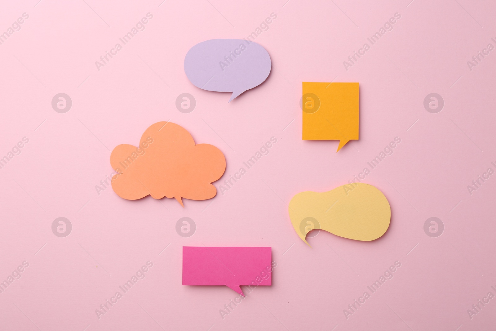 Photo of Equality concept. Different paper speech bubbles on pink background, flat lay