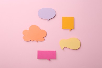 Photo of Equality concept. Different paper speech bubbles on pink background, flat lay