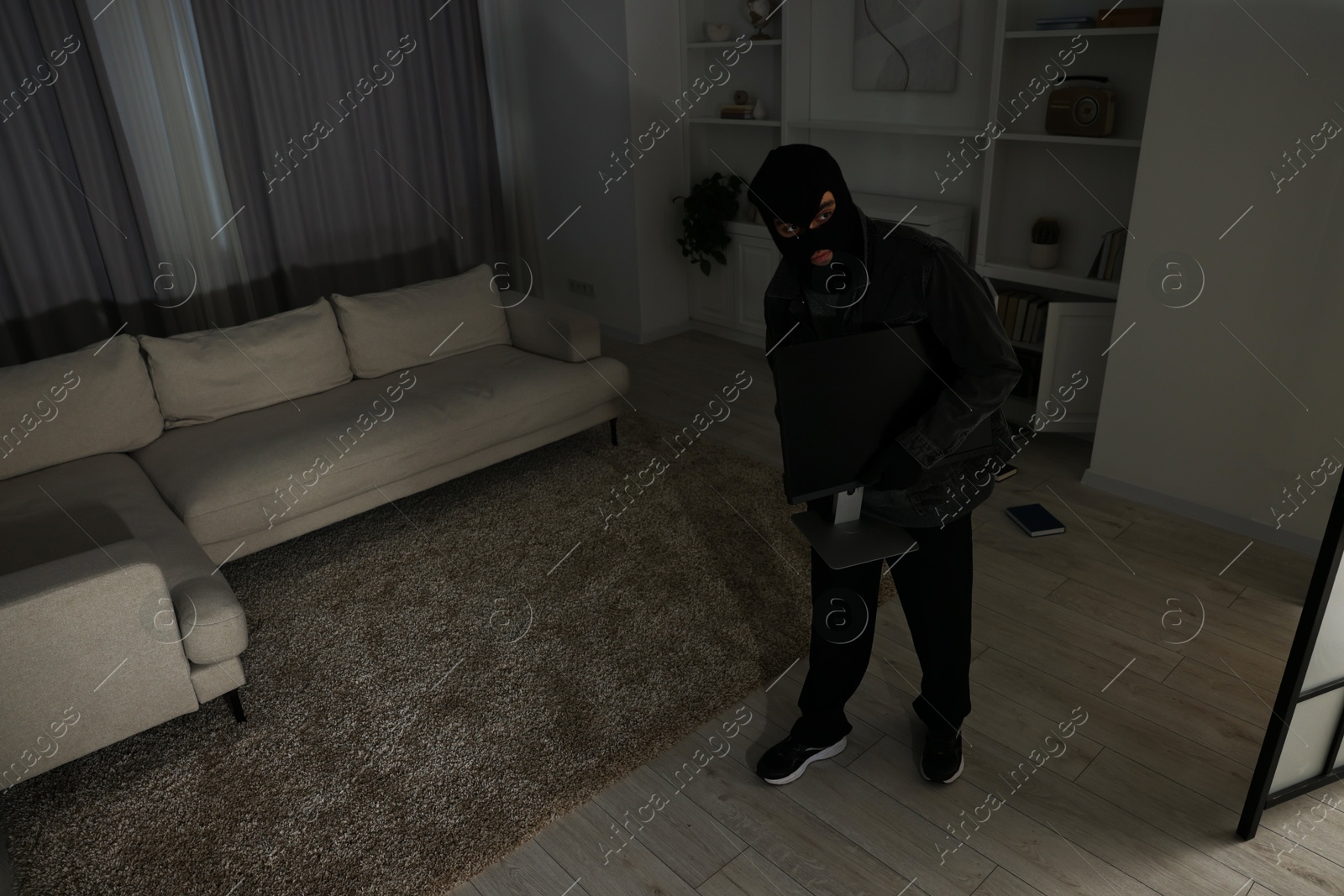 Photo of Thief entering foreign house at night. Burglary