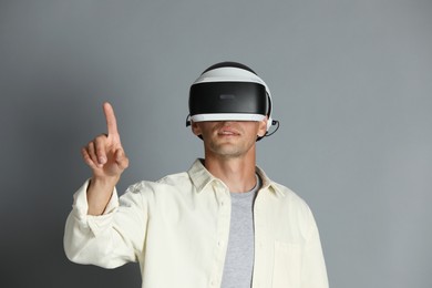 Man using virtual reality headset on gray background