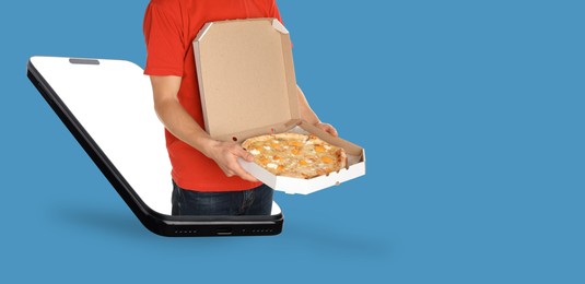 Image of Online food ordering. Man with pizza sticking out of smartphone screen against blue background. Banner design with space for text
