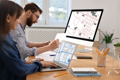 Image of Cartographers working with cadastral maps at table in office