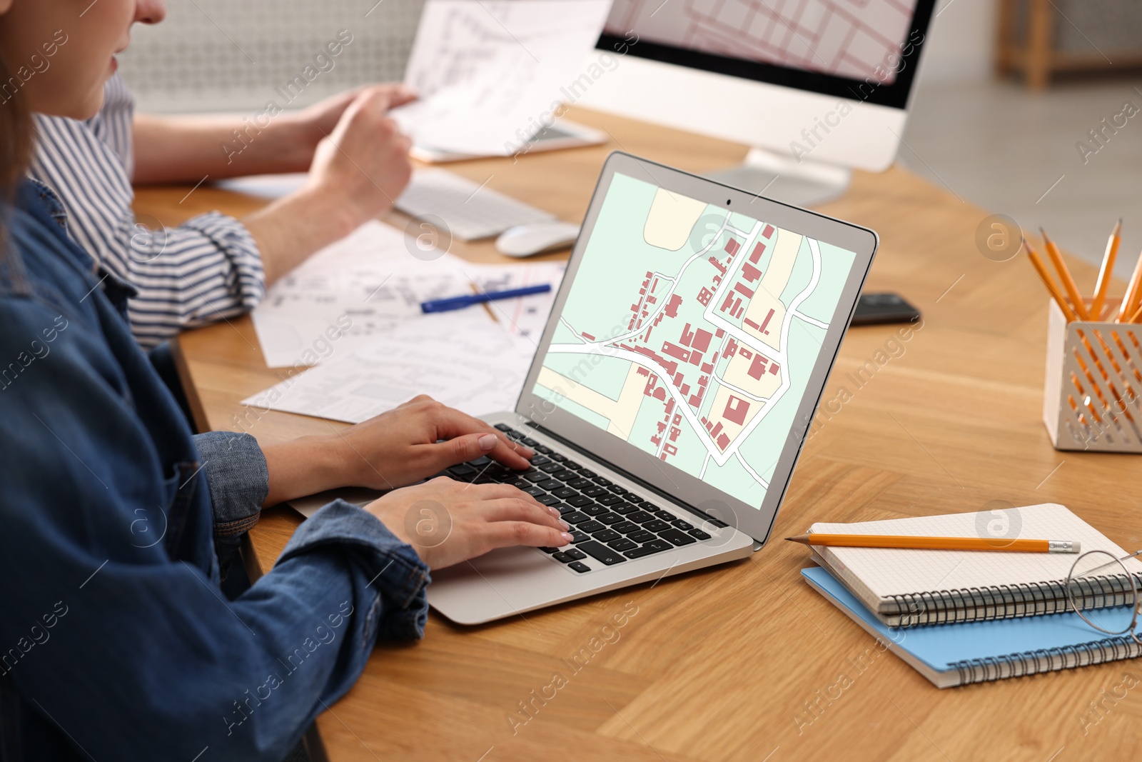 Image of Cartographers working with cadastral maps at table in office, closeup