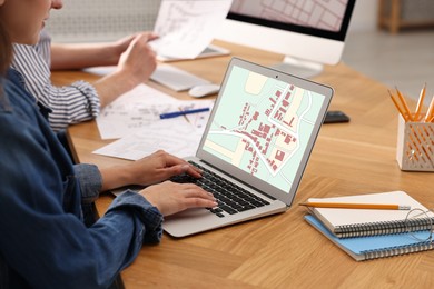 Image of Cartographers working with cadastral maps at table in office, closeup