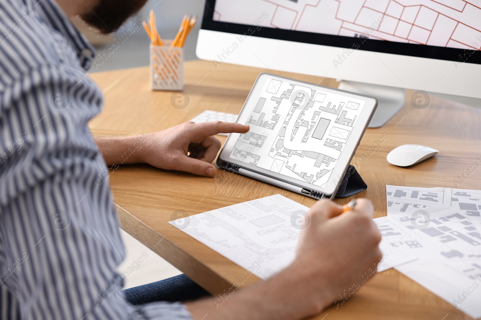 Image of Man working with cadastral map on tablet at table in office, closeup