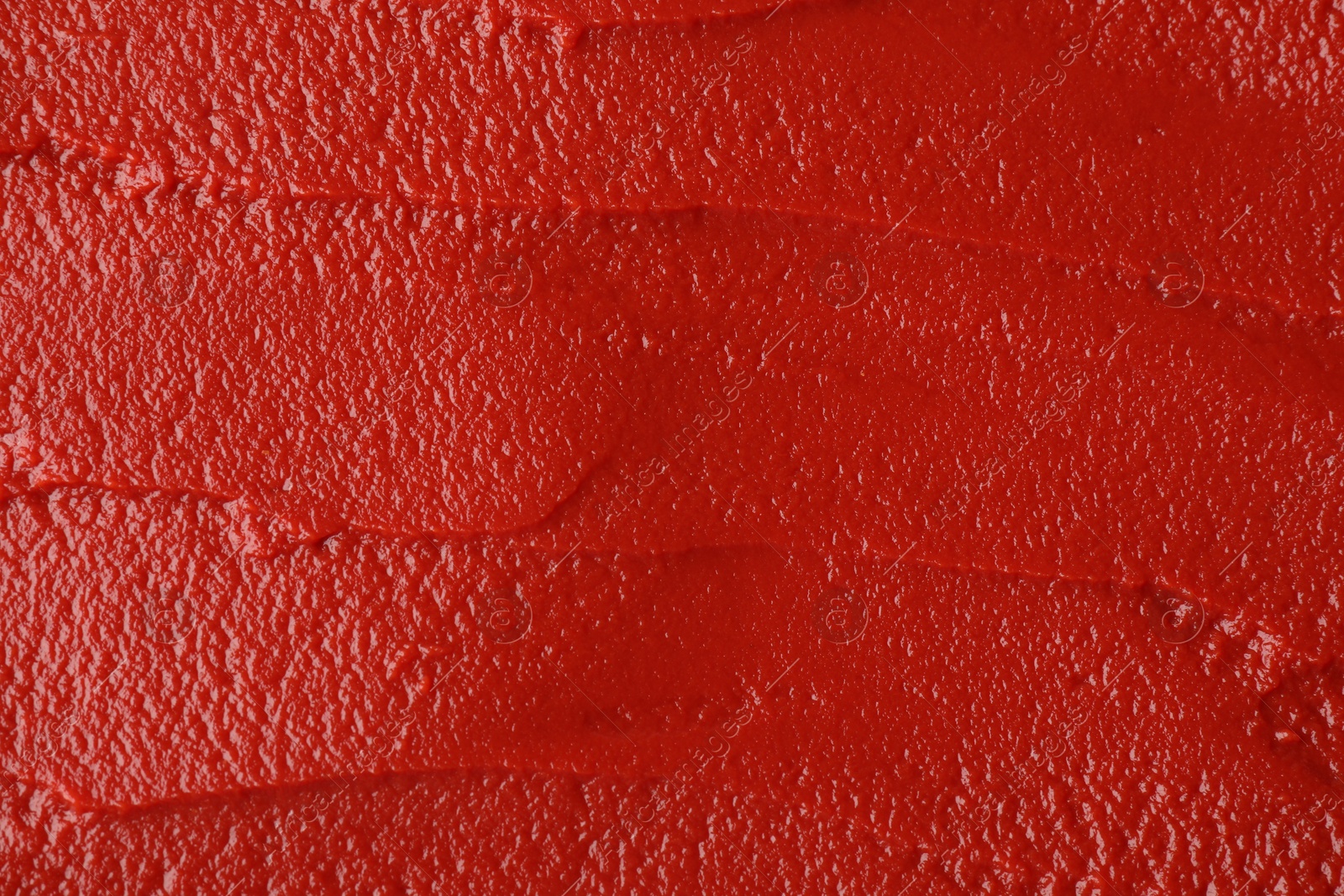 Photo of Texture of ketchup as background, top view. Tomato sauce