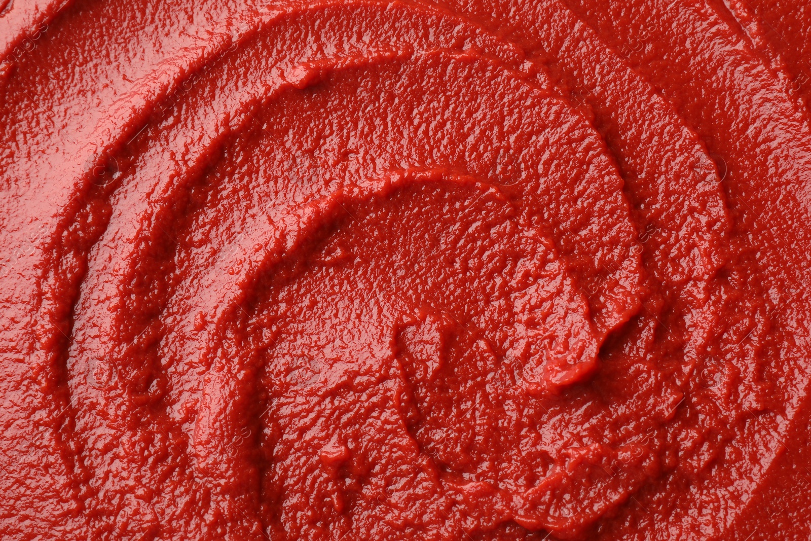 Photo of Texture of ketchup as background, top view. Tomato sauce