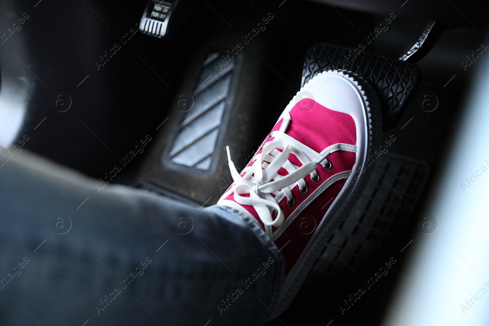 Photo of Woman pushing on pedal of car brake, closeup