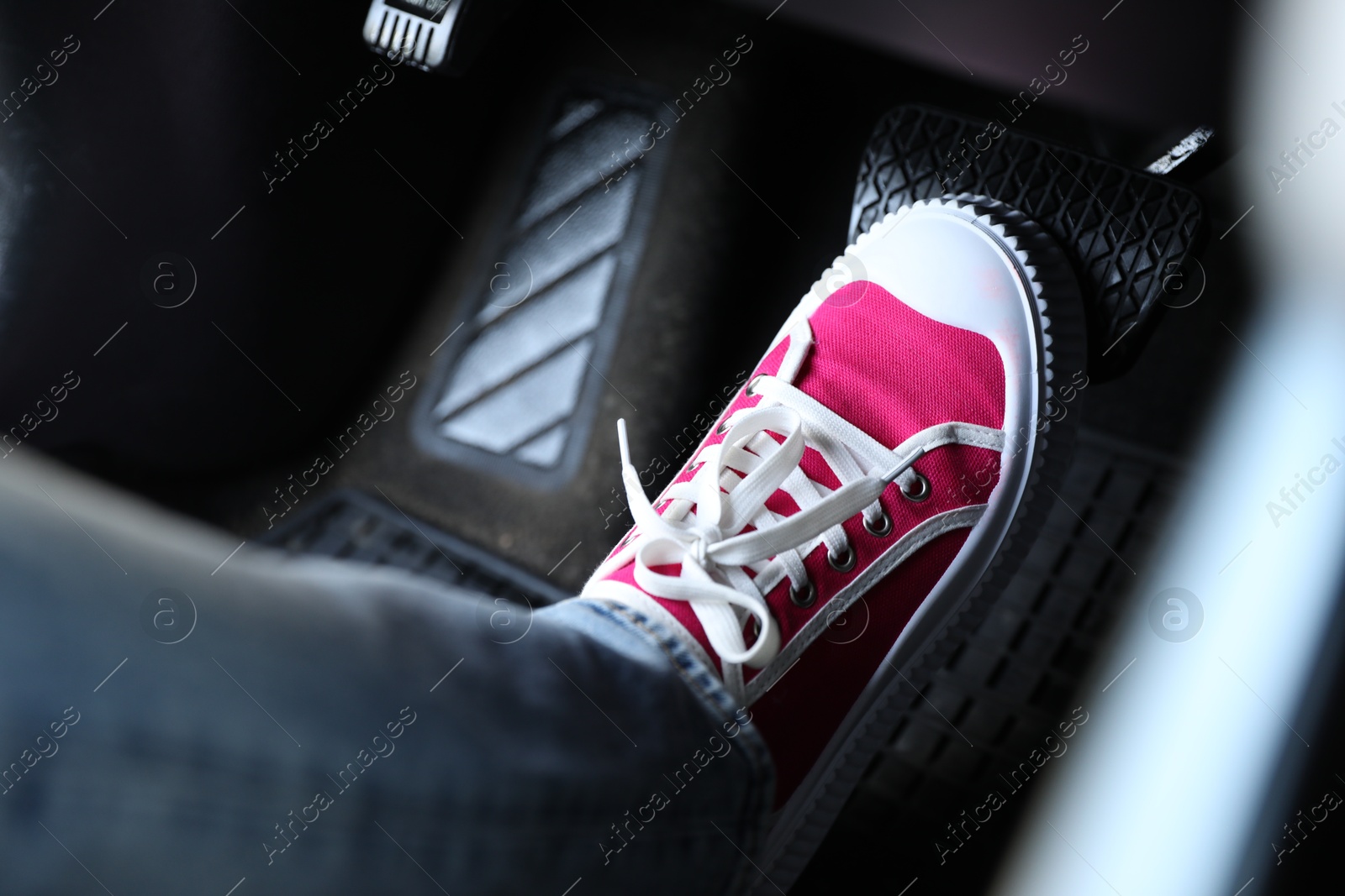 Photo of Woman pushing on pedal of car brake, closeup