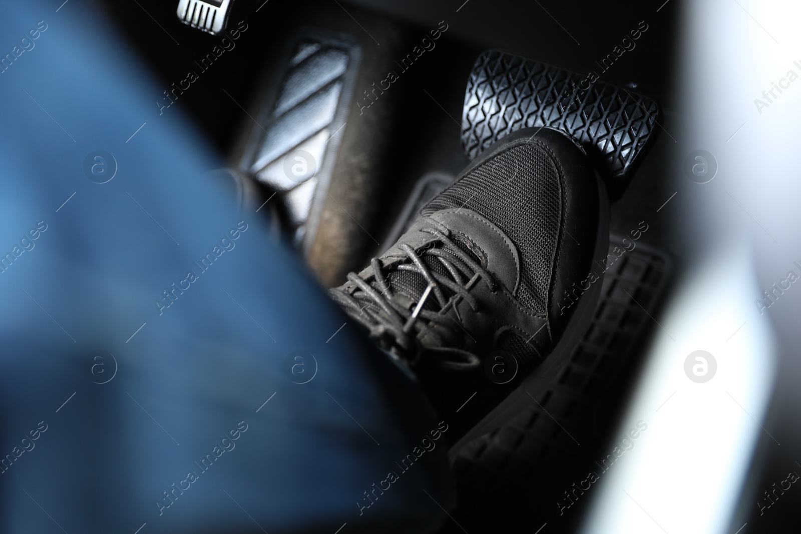 Photo of Man pushing on pedal of car brake, closeup