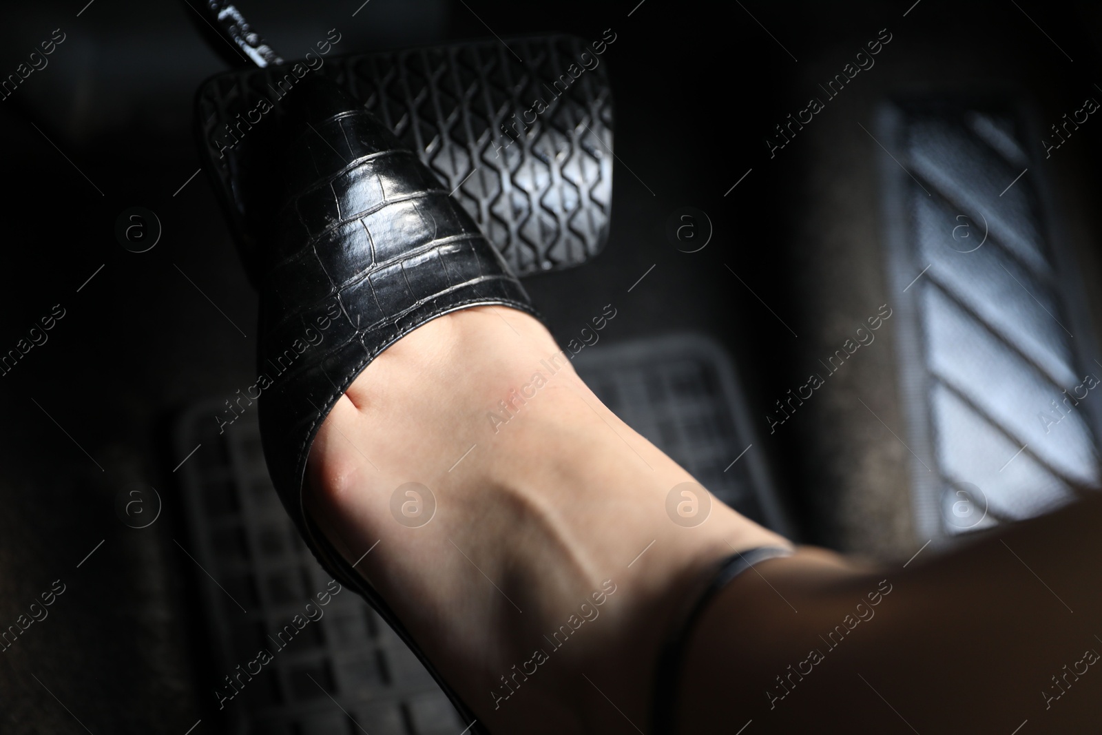 Photo of Woman pushing on pedal of car brake, closeup