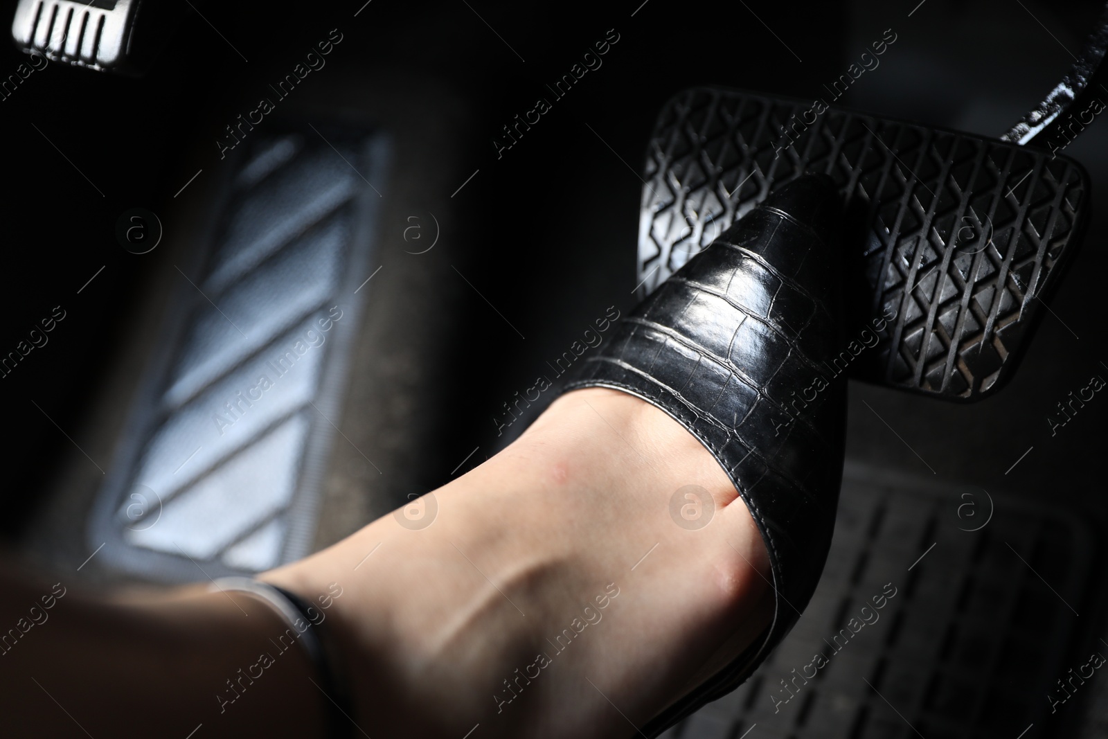 Photo of Woman pushing on pedal of car brake, closeup