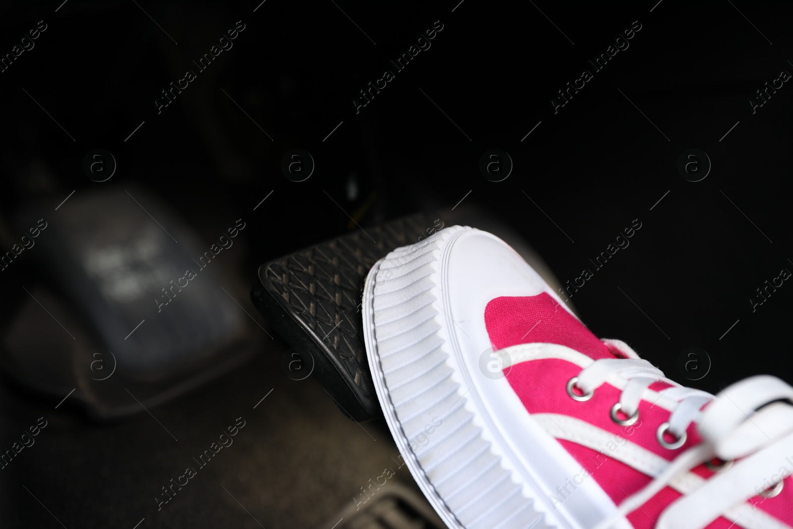 Photo of Woman pushing on pedal of car brake, closeup