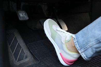 Photo of Woman pushing on pedal of car brake, closeup