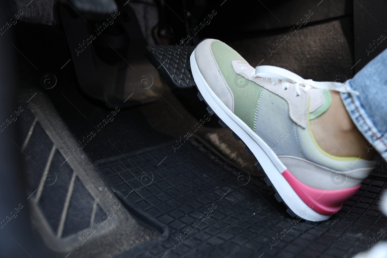 Photo of Woman pushing on pedal of car brake, closeup