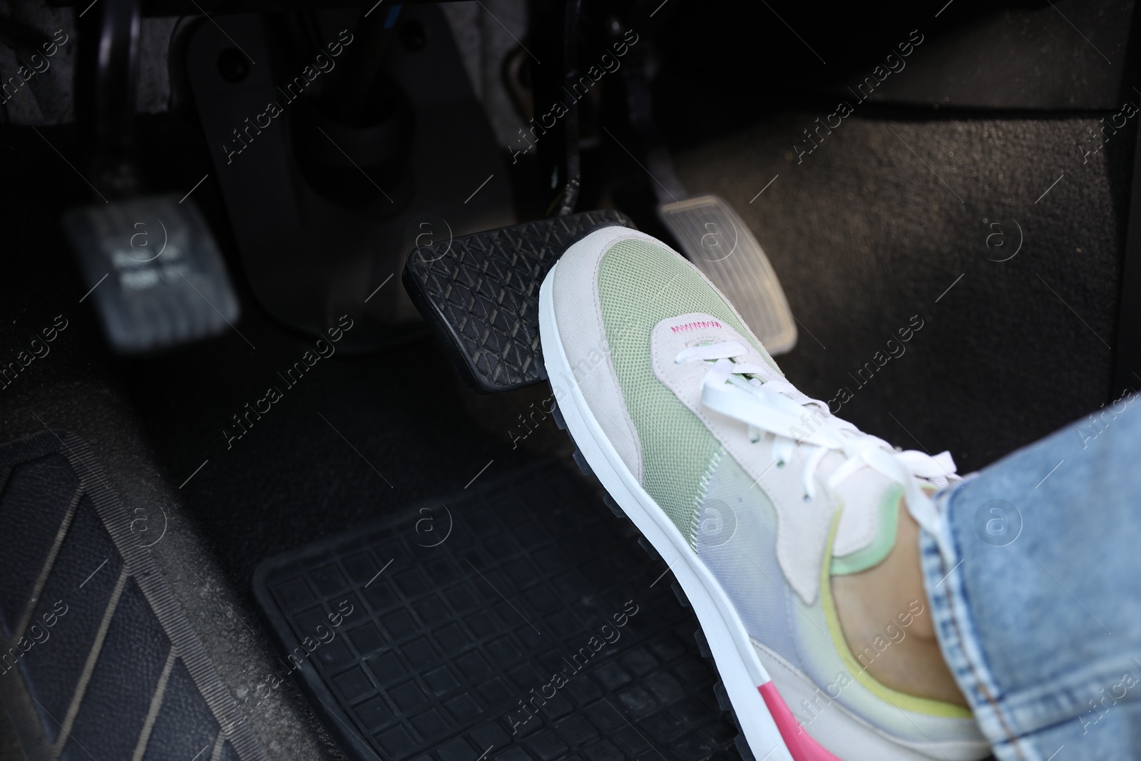 Photo of Woman pushing on pedal of car brake, closeup