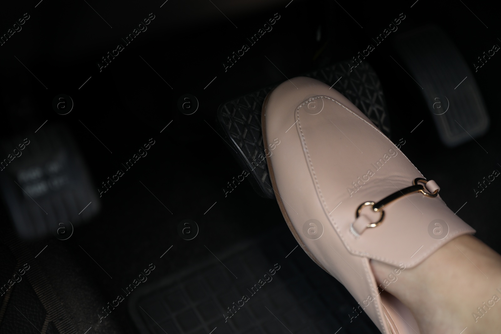 Photo of Woman pushing on pedal of car brake, closeup