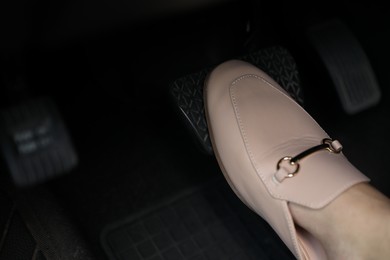 Photo of Woman pushing on pedal of car brake, closeup