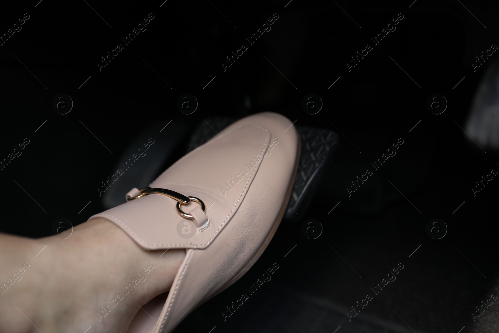 Photo of Woman pushing on pedal of car brake, closeup