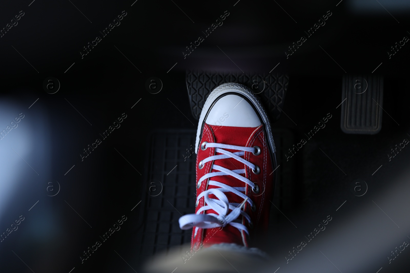 Photo of Woman pushing on pedal of car brake, closeup