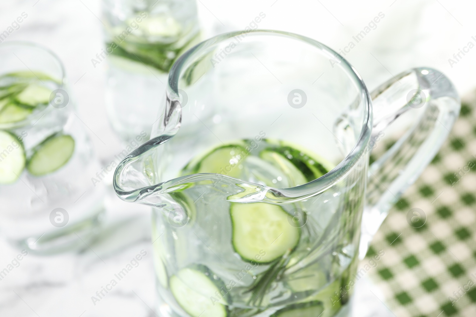 Photo of Refreshing cucumber water with rosemary in jug on table, closeup