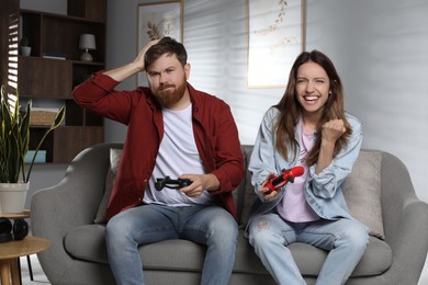 Couple playing video game with controllers at home