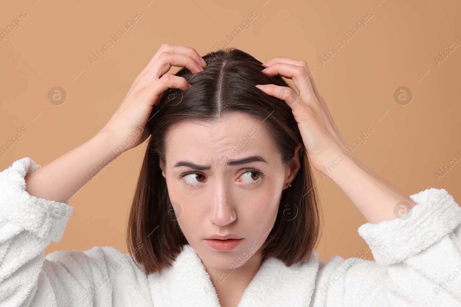 Photo of Sad woman with hair loss problem on light brown background