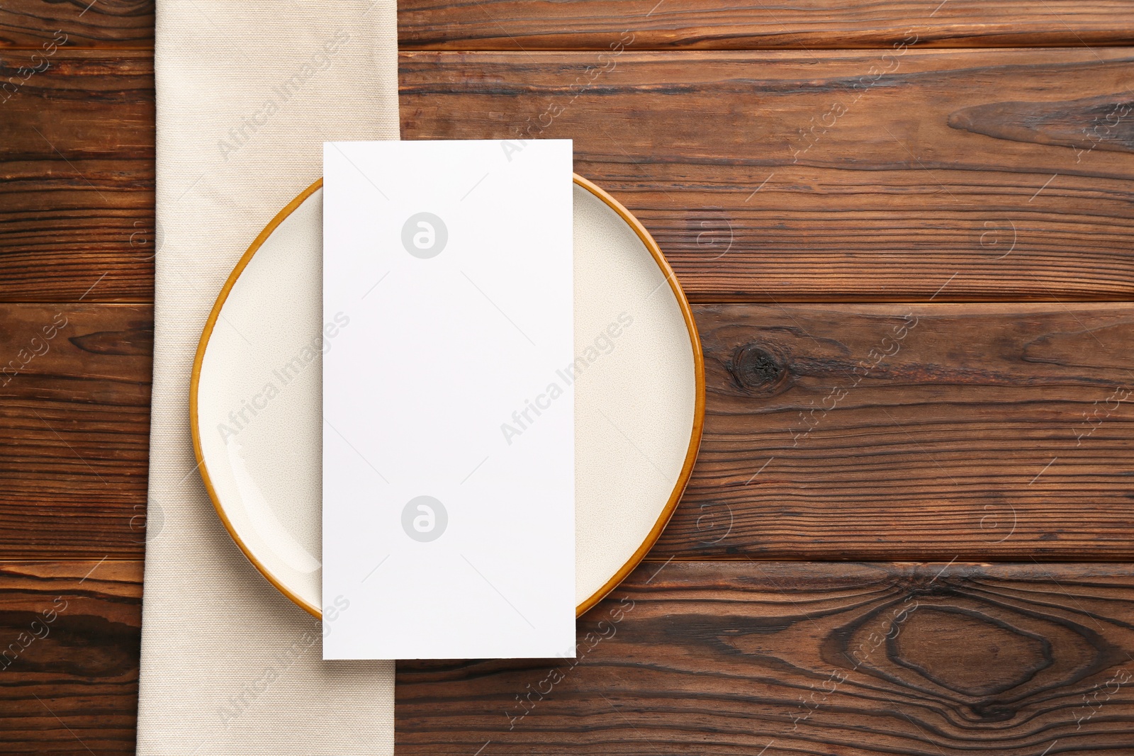 Photo of Empty menu, plate and napkin on wooden table, top view. Mockup for design