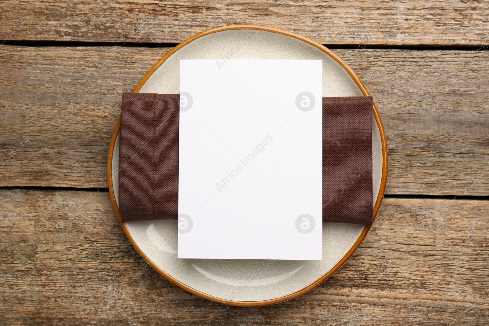 Photo of Empty menu, plate and napkin on wooden table, top view. Mockup for design