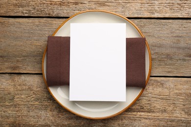 Photo of Empty menu, plate and napkin on wooden table, top view. Mockup for design